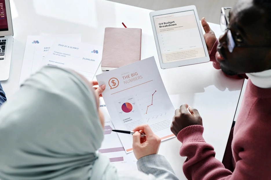A person thoughtfully reviewing their budget on a tablet in a calm, well-lit room.